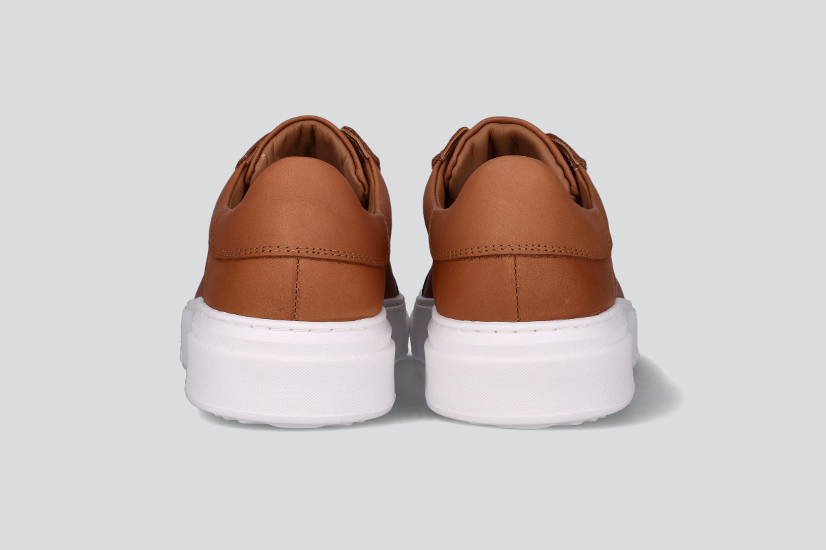 The heels of a pair of cognac men's low top sneaker from the Hartt Shoe Company