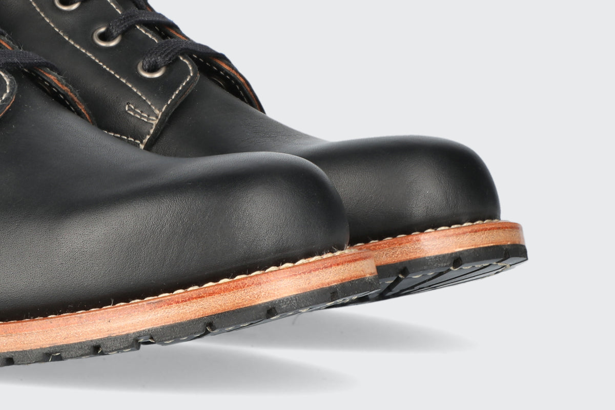 The toes of a pair of men's black leather boots.