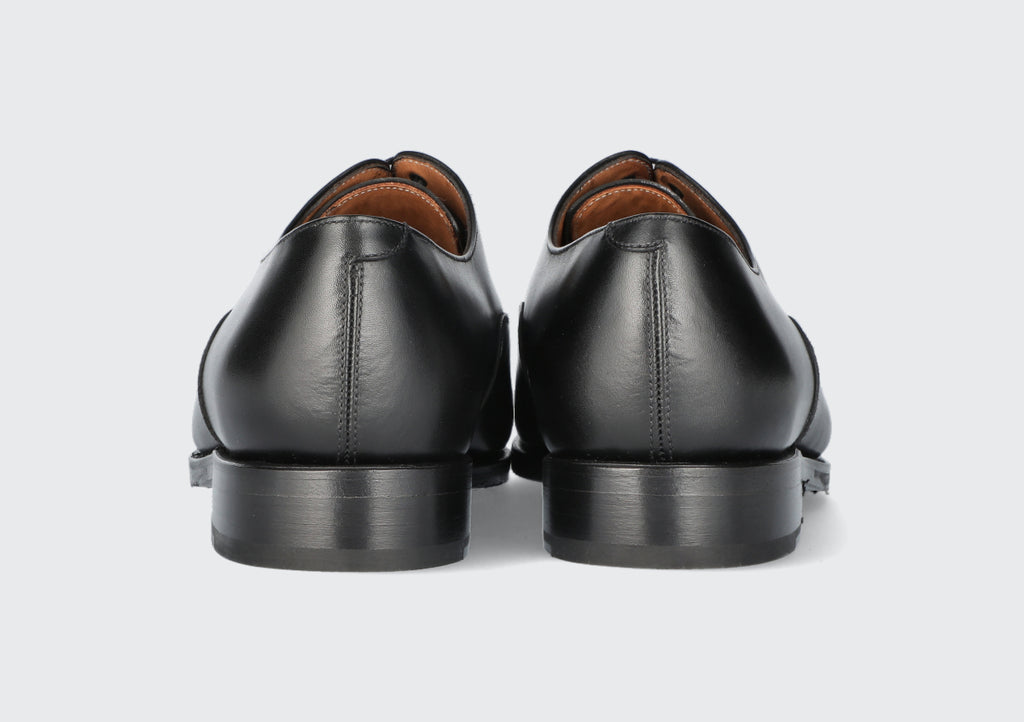 The heels of a pair of black leather dress shoes from the Hartt Shoe Company