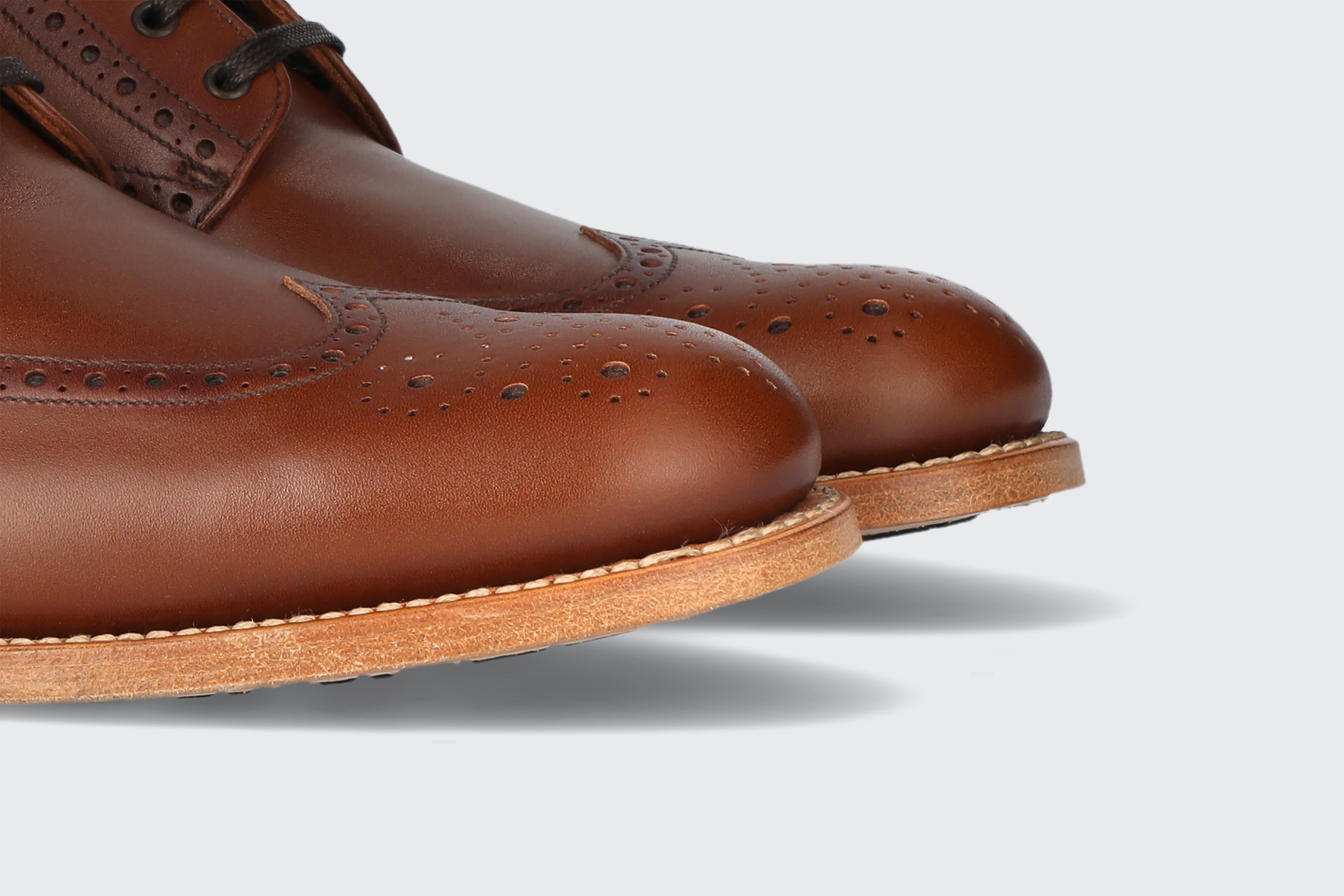 The toes of a pair of brown leather dress boots from the Hartt Shoe Company