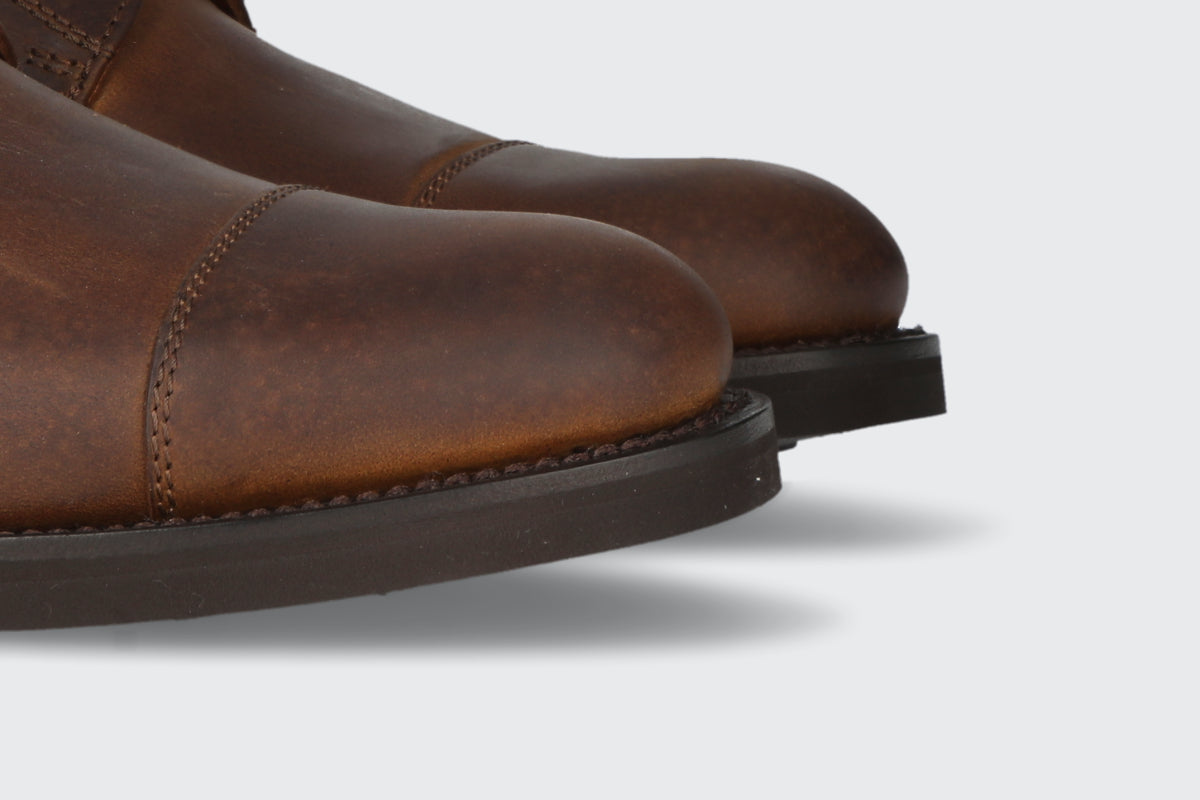 The toes of a pair of men's tan leather boots from the Hartt Shoe company