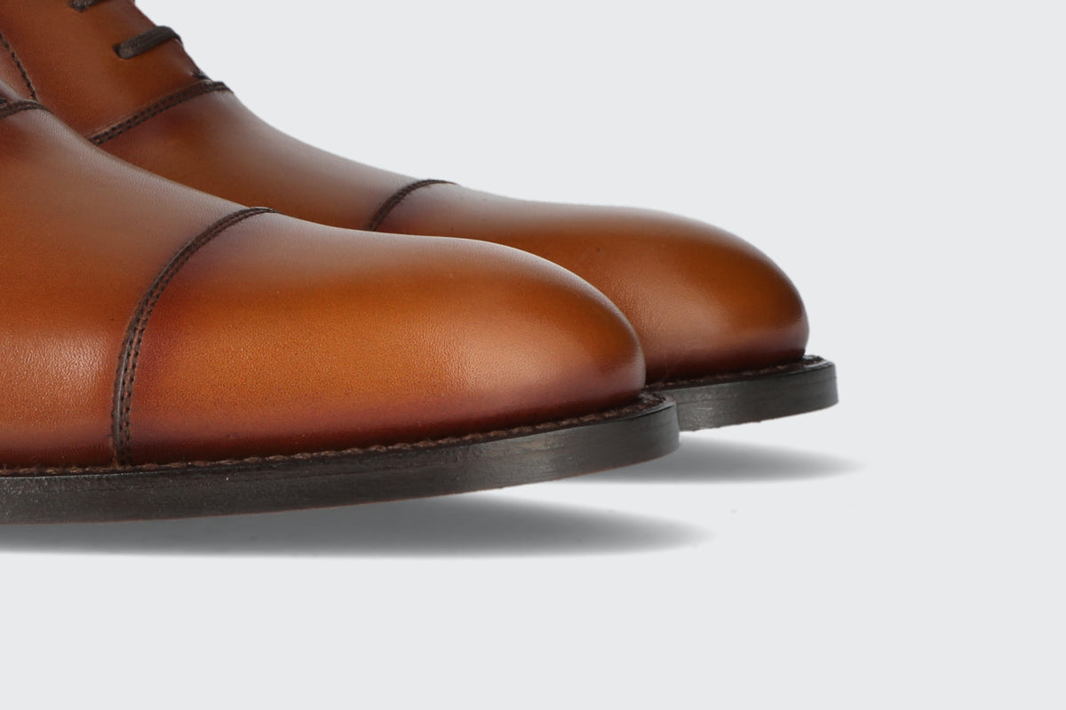 The toes of a pair of brown leather dress shoes from the Hartt Shoe Company