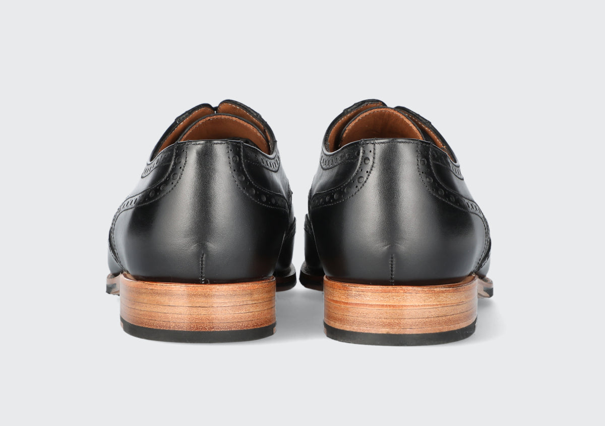 The heels of a pair of black leather dress shoes from the Hartt Shoe Company