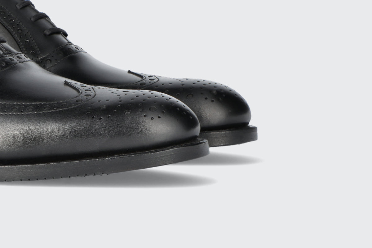 The toes of a pair of black leather dress shoes from the Hartt shoe company
