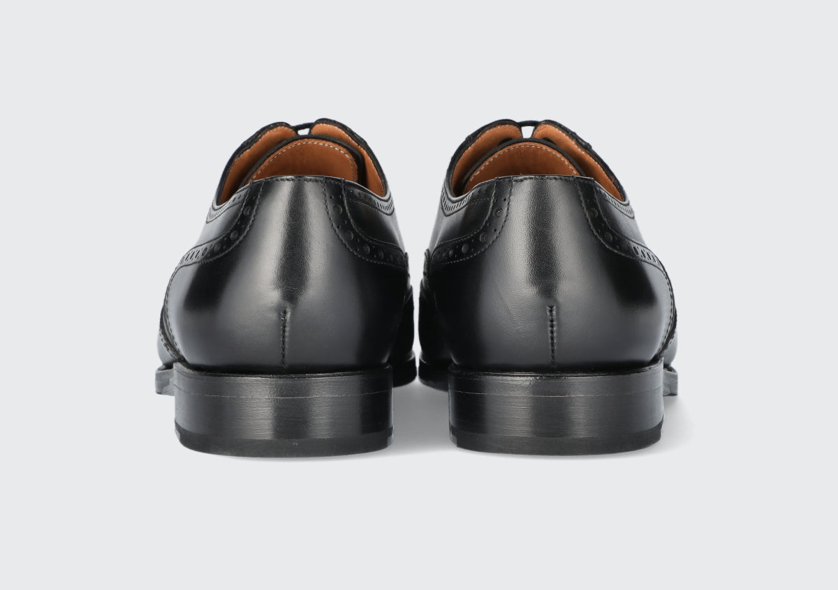 The heels of a pair of black leather dress shoes from the Hartt Shoe company