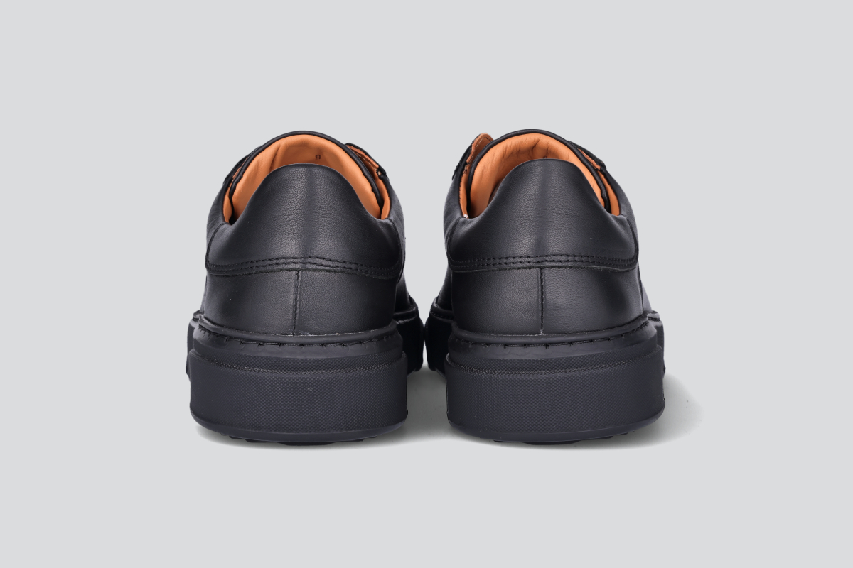 The heels of a pair of black men's low top sneaker from the Hartt Shoe Company