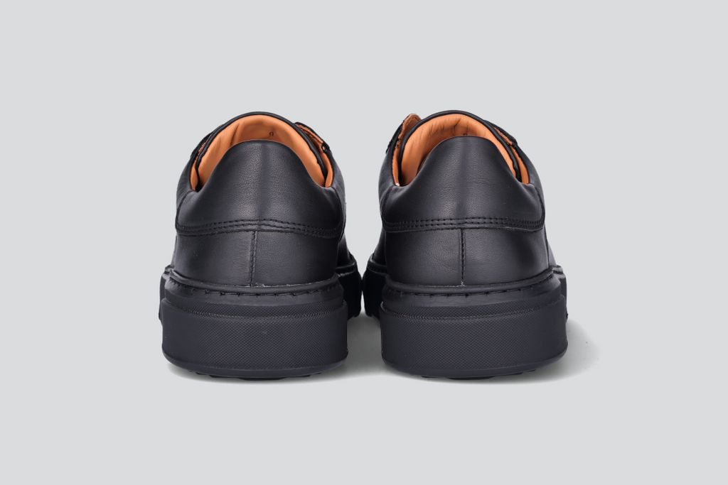 The heels of a pair of black men's low top sneaker from the Hartt Shoe Company