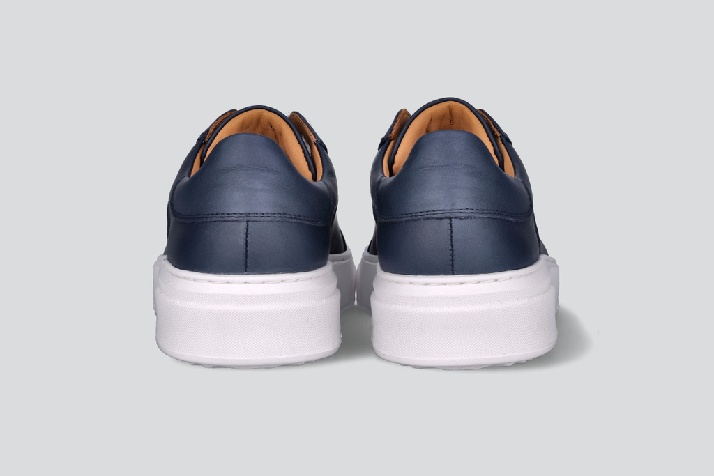 The heels of a pair of navy men's low top sneaker from the Hartt Shoe Company