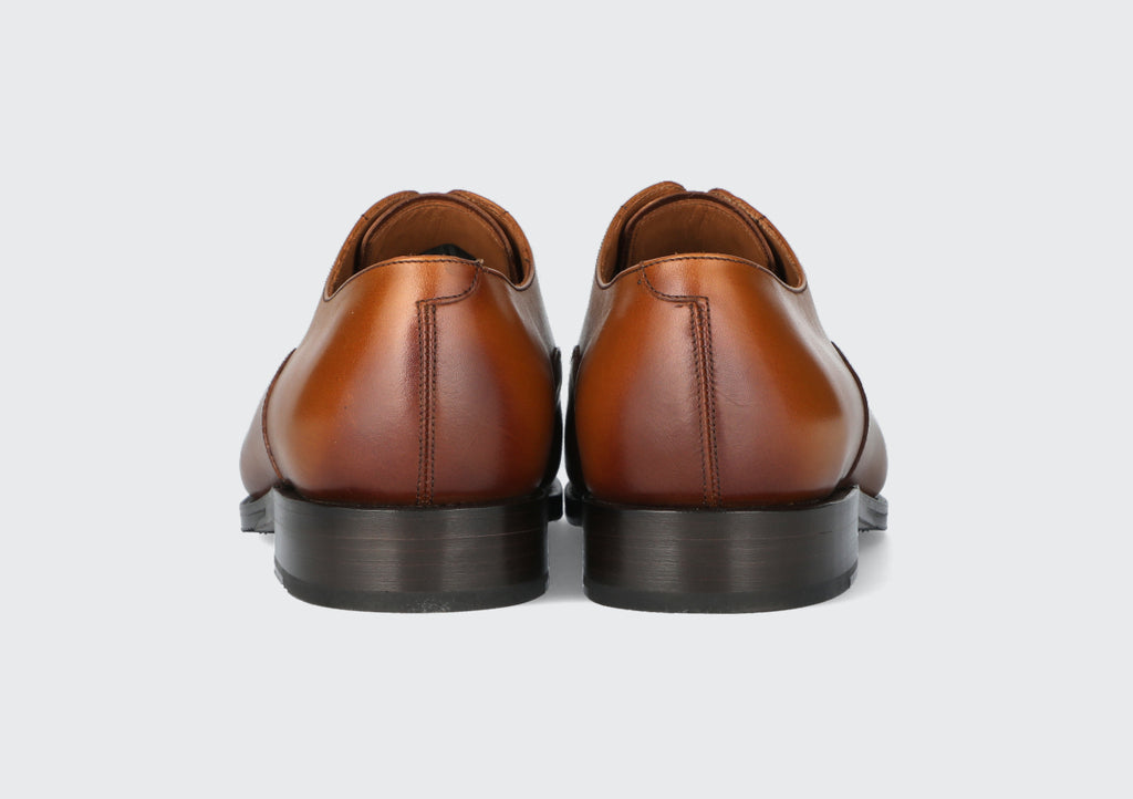 The heels of a pair of mens leather dress shoes made by the Hartt Shoe Company