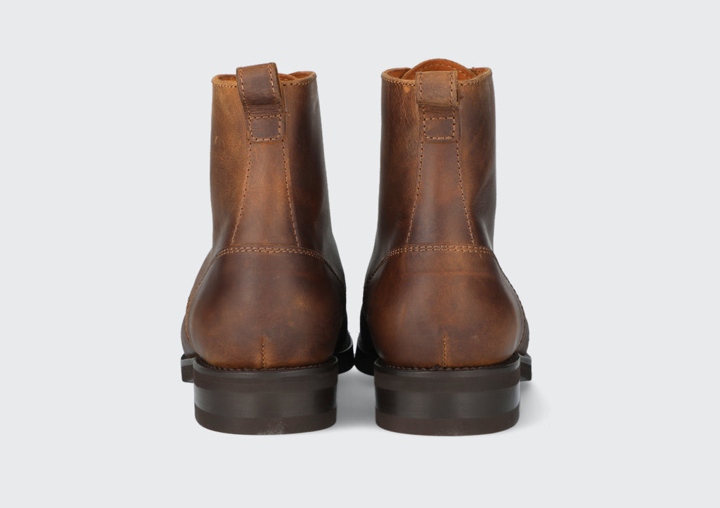The heels of pair of tan leather dress boots from the Hartt Shoe Company