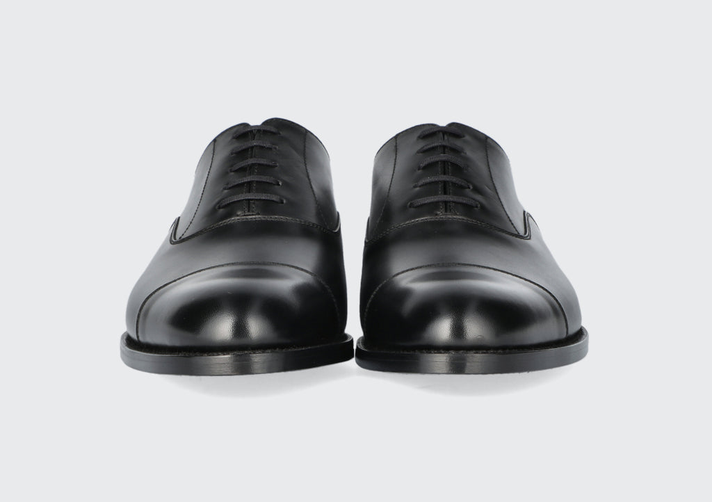 The front of a pair of black leather dress shoes from the Hartt Shoe Company