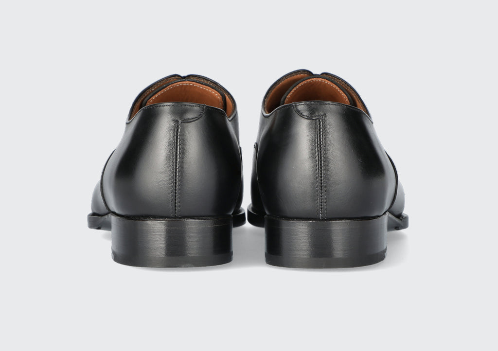 The heels of a pair of black leather dress shoes from the Hartt Shoe company