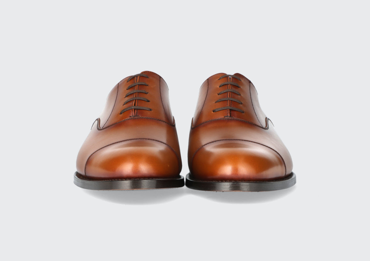 The front of a pair of brown leather dress shoes from the Hartt Shoe Company
