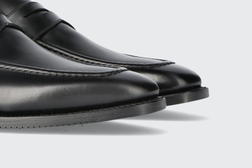 The toes of a pair of black leather loafers from the Hartt Shoe Company