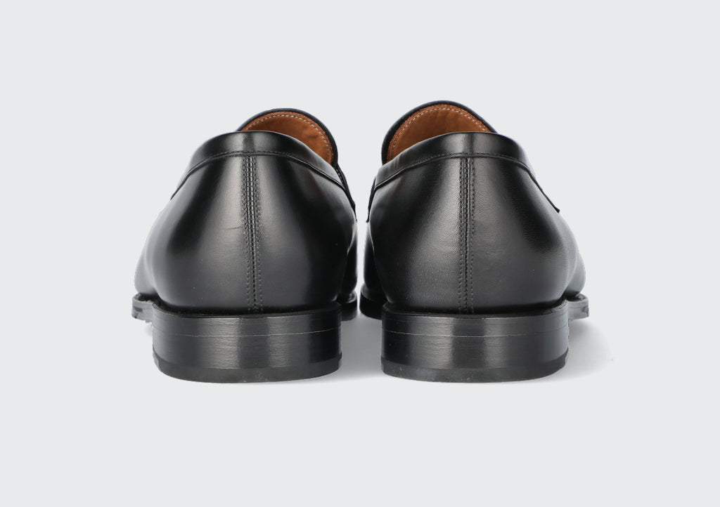 The heels of a pair of black leather loafers from the hartt Shoe company