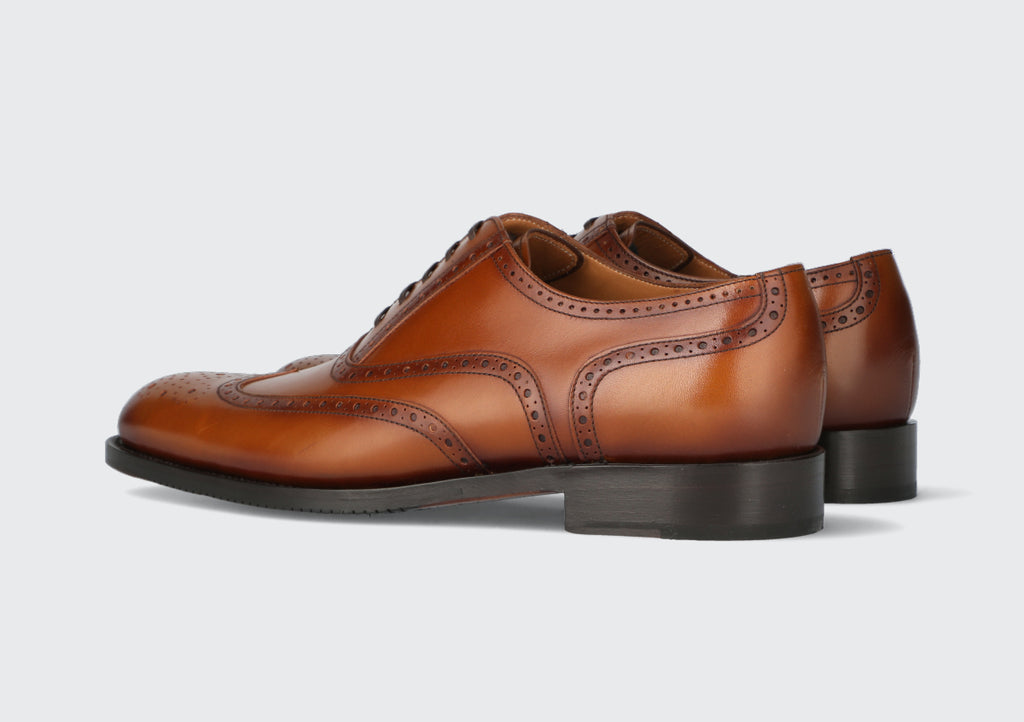 A pair of brown leather dress shoes with brogueing from the Hartt Shoe Company